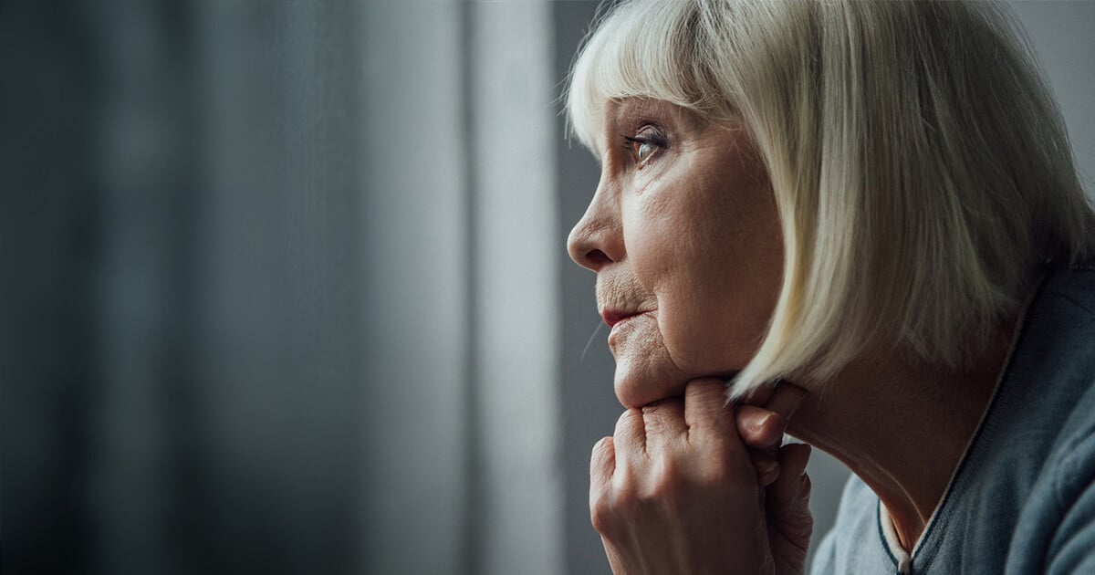 Woman looking melancholically out of the window